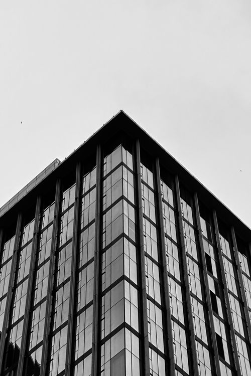 Free A striking black and white perspective of a modern skyscraper downtown. Stock Photo