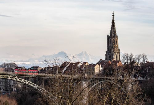 Free View of Bern Cathedral and bridge with snowy mountains in the background, Switzerland. Stock Photo