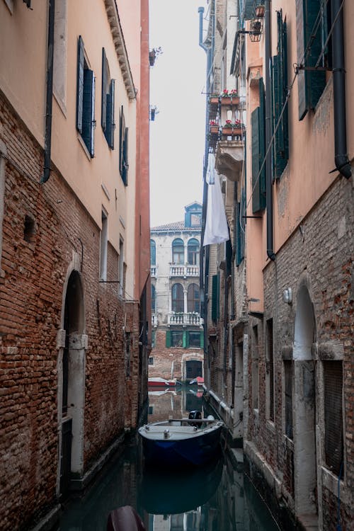 A boat is in a narrow canal in venice