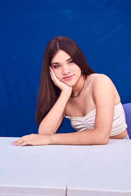 A young woman sitting at a table with her arms crossed
