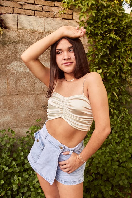A young woman posing for a photo in a crop top and shorts