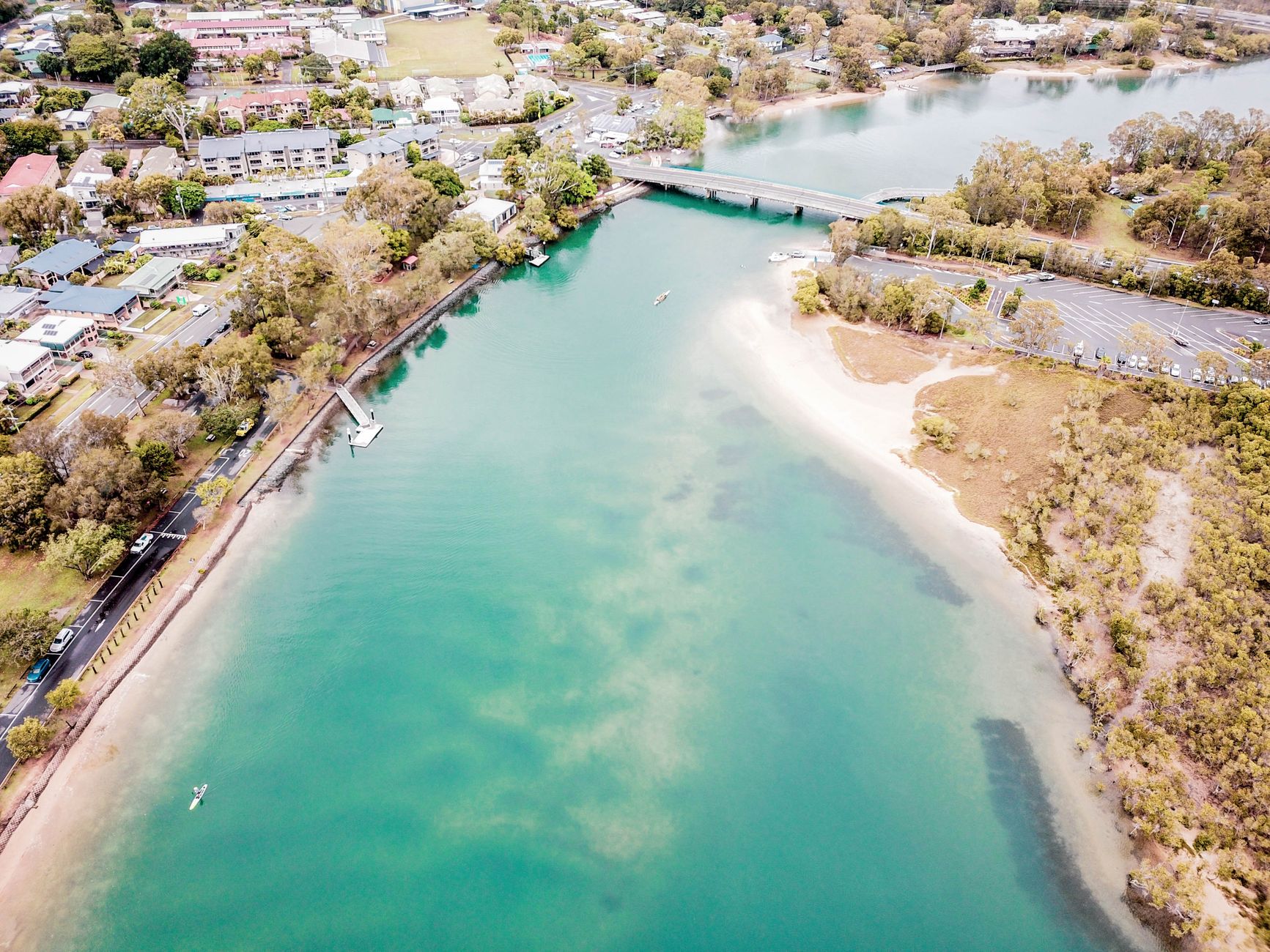 A breathtaking aerial view of Currumbin Creek, showcasing turquoise waters and lush green surroundings.