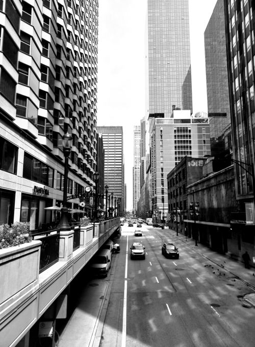 Free Black and white view of a bustling street in downtown Chicago lined with towering skyscrapers. Stock Photo