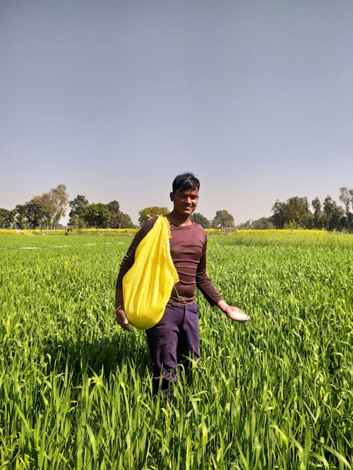 Farmer Standing with Bag on Field