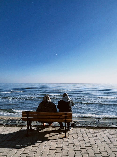 Couple Sitting on Promenade on Sea Shore