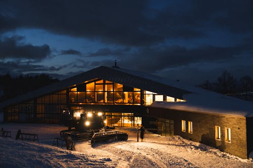 A large building with a ski slope lit up at night