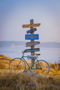 A nostalgic bicycle and coastal signs pointing to beach life.