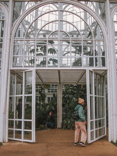 Person Opening Doors of Greenhouse in Botanical Garden