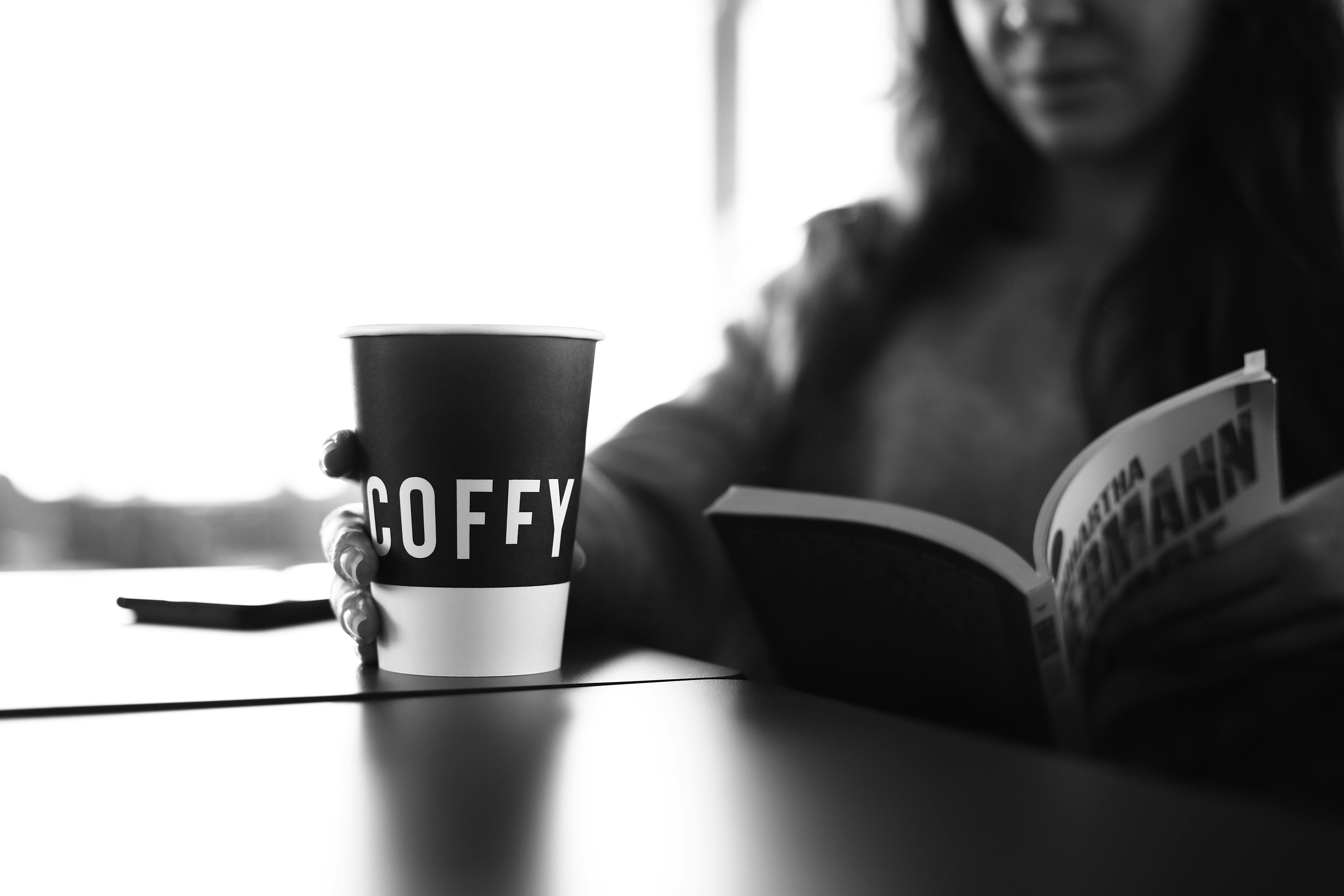 A woman holding a coffee cup with the word coffee on it