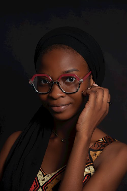 A young woman wearing glasses and a head scarf