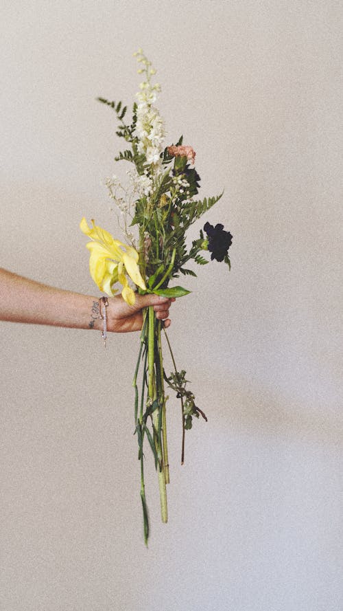 A person holding a bouquet of flowers in their hand