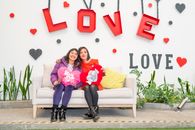 Two women sitting on a sofa with love decorations in Ciudad de México.