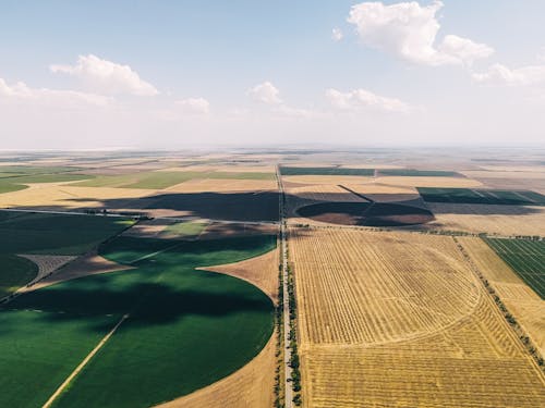 An aerial view of a farm field with a large green field