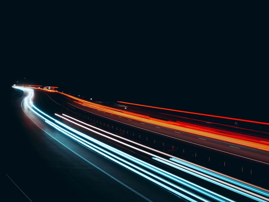 Captivating long exposure of streaking car lights on a highway at night, showcasing vibrant motion and speed.
