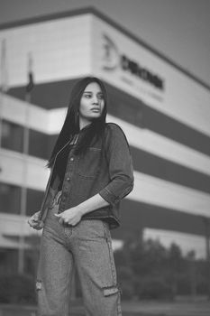 Black and white portrait of a woman in denim, capturing modern fashion outdoors.