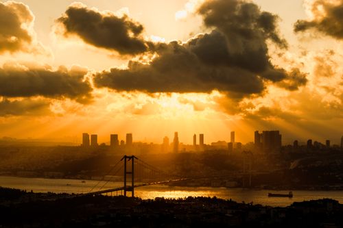 Free Stunning sunset view over the Bosphorus Bridge in Istanbul with golden clouds highlights the city skyline. Stock Photo