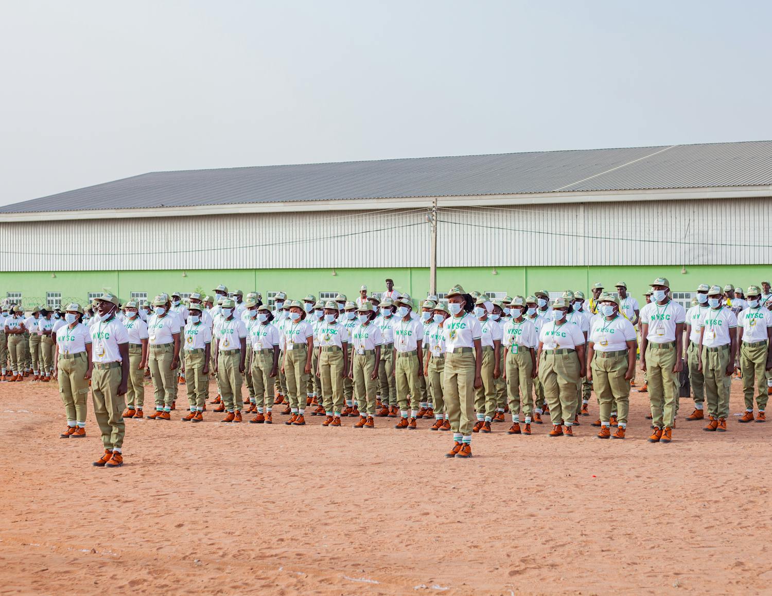 A large group of uniformed individuals standing in formation outdoors, illustrating discipline and unity.