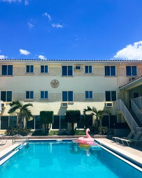 Vibrant scene of a sunny resort pool with a pink flamingo float in St. Pete Beach, Florida.