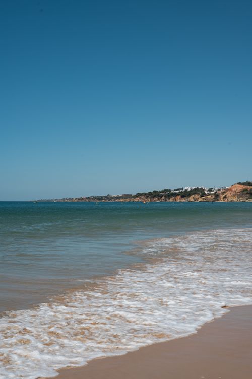 Free Calm waves on a sunny day at Albufeira beach, Portugal, with clear skies. Stock Photo