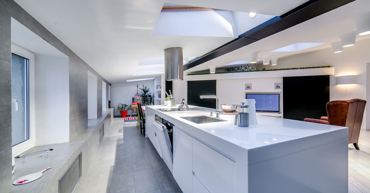 Bright and spacious modern kitchen interior with skylights and sleek design elements.