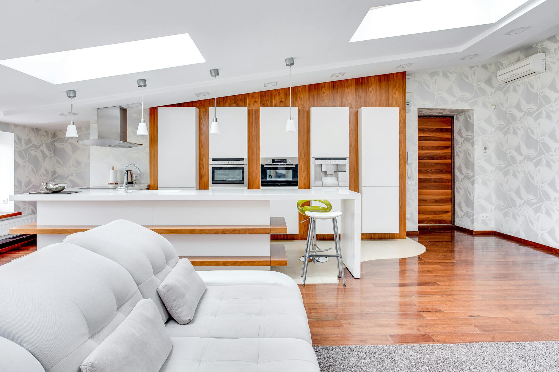 A modern kitchen with white cabinets and wooden floors