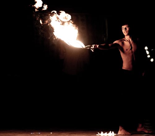 Free A topless fire performer skillfully handles flames against a dark backdrop, creating a dramatic scene. Stock Photo