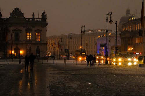 People walking on a snowy street at night