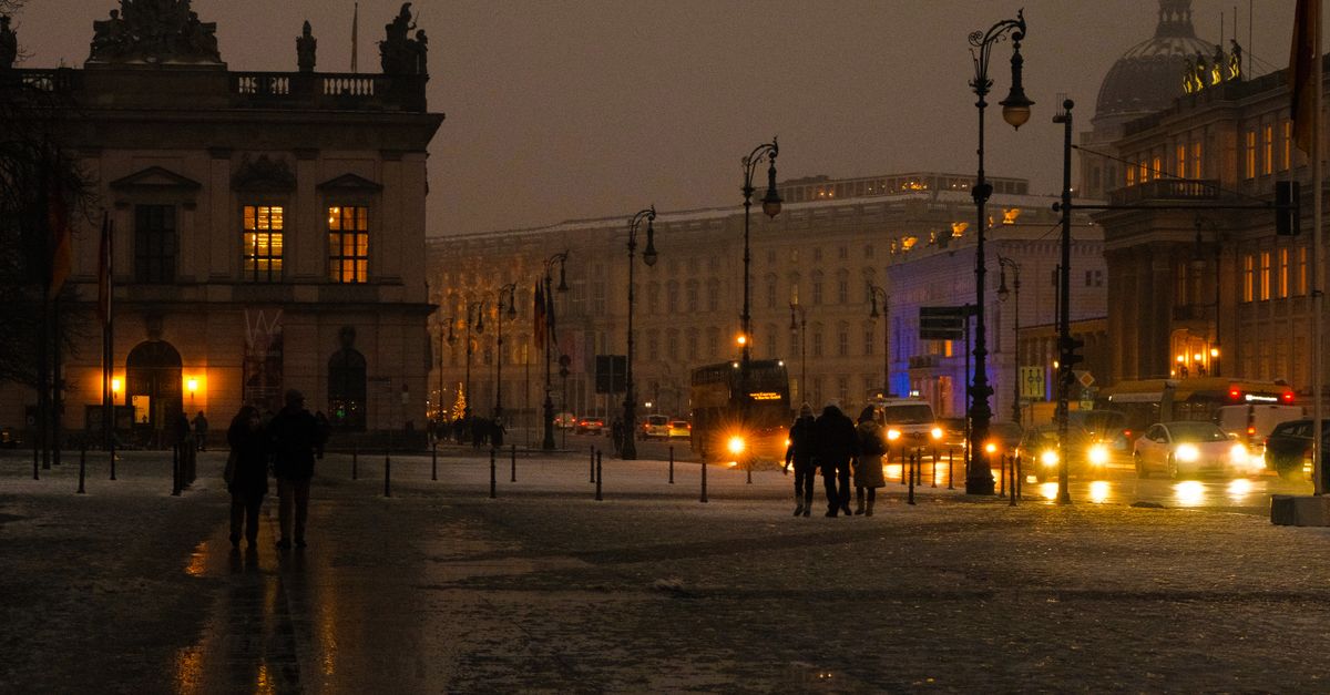 A Berlin street on a winter evening, lit windows and people walking