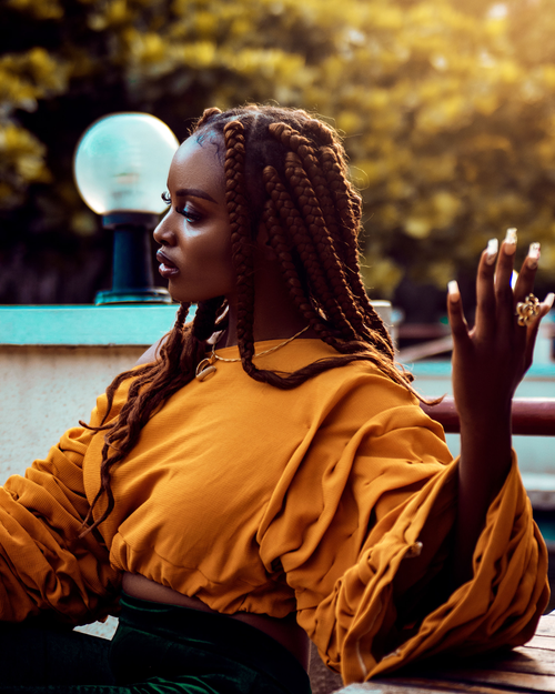 Free A fashionable African woman wearing yellow, enjoying an outdoor scene in Lagos, Nigeria. Stock Photo