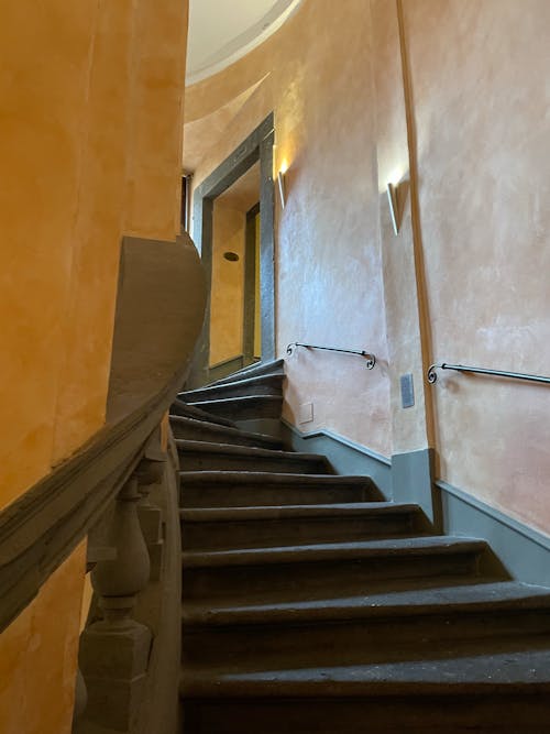 A staircase with a railing and a wall with a yellow and white color