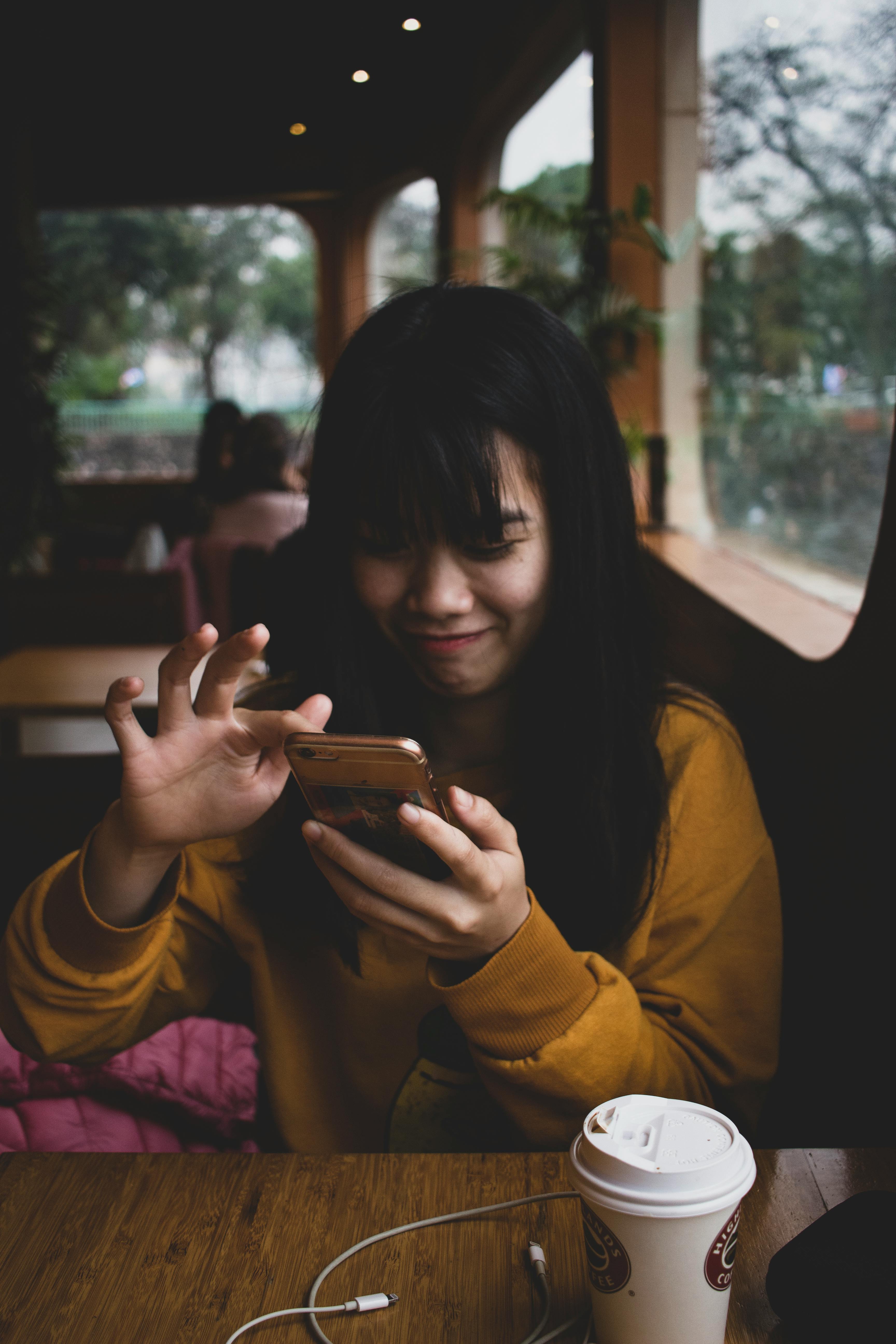 smiling woman sitting with cellphone
