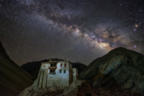 The milky shines over a building in the mountains