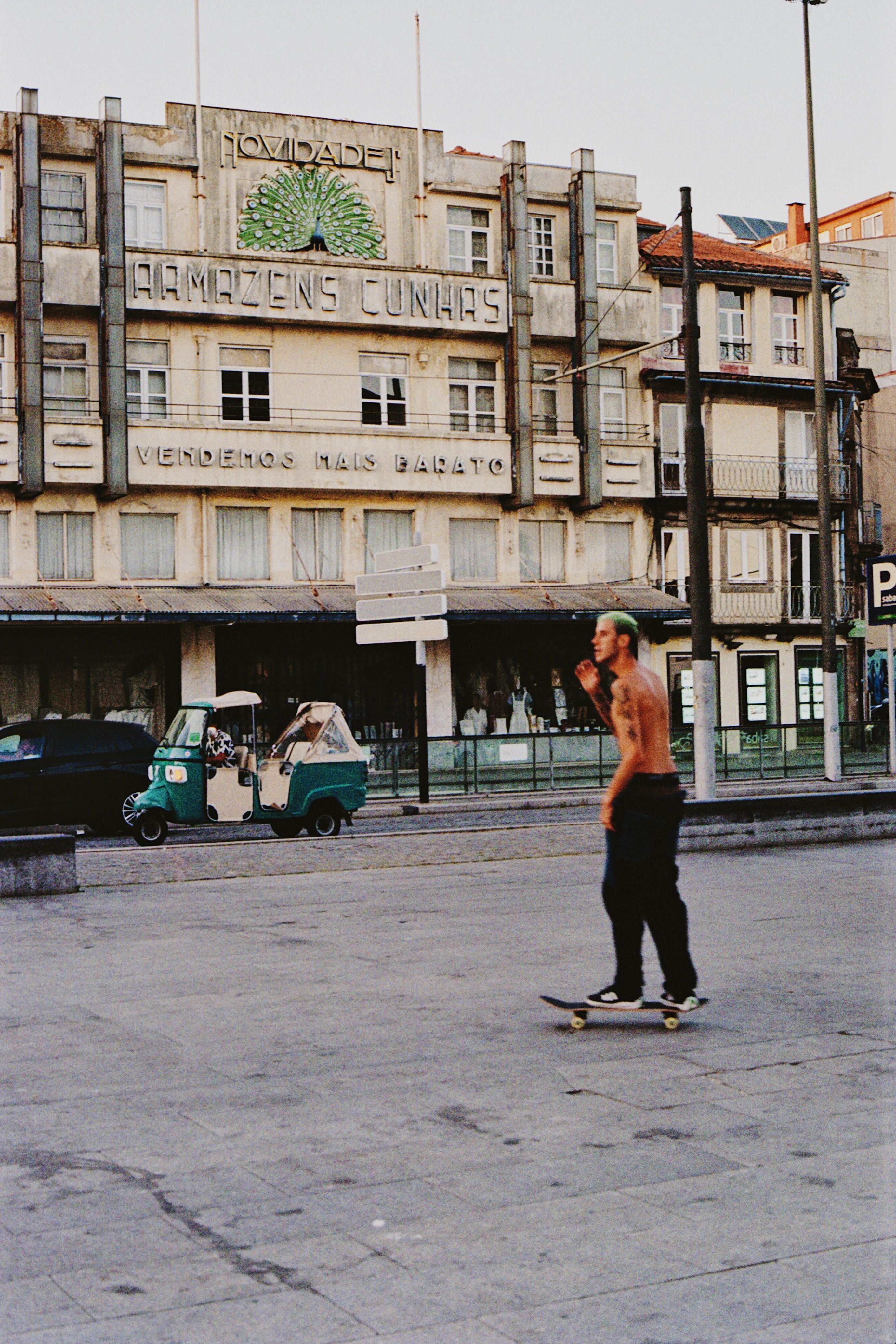 A skateboarder rides past a historic building facade in Porto, Portugal, embodying urban street culture.