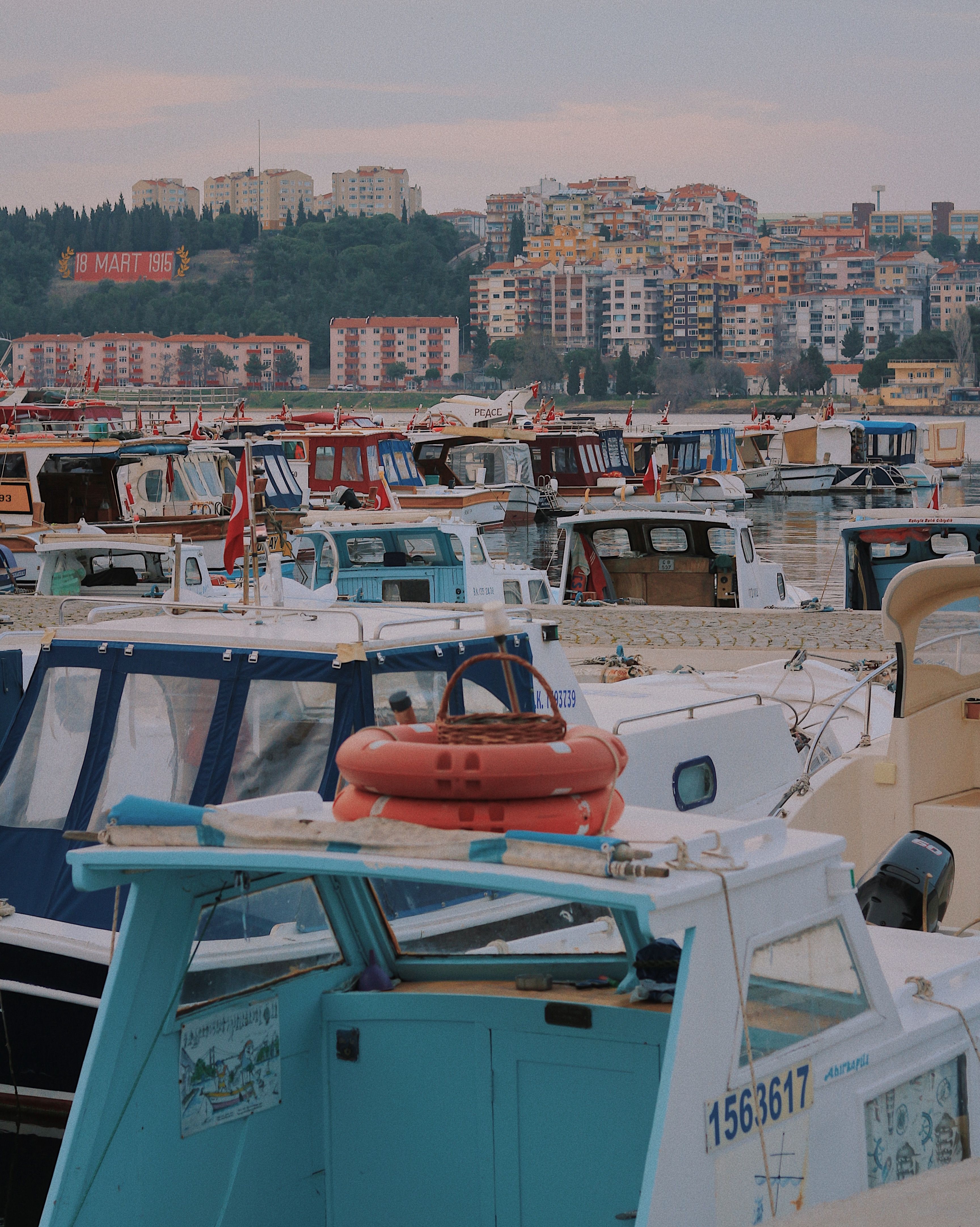 Vibrant marina scene with boats moored along a bustling coastal city, capturing the essence of travel and urban life.