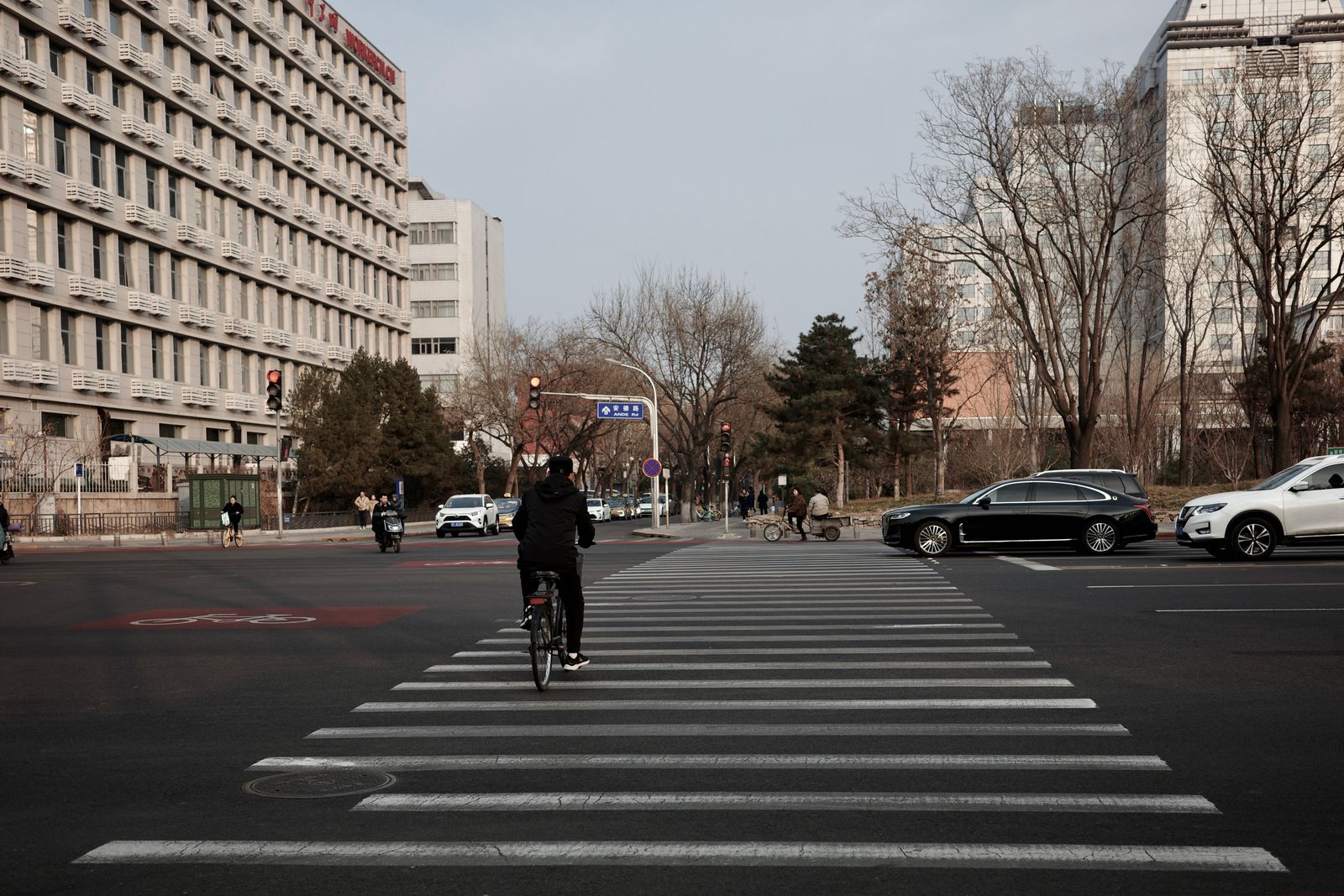 Cyclist crossing a city street with vehicles