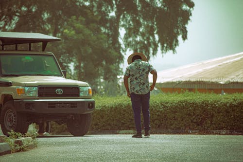 Back View of Man Walking on Street near Car