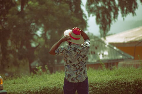 Back View of Man in Colorful Shirt and Hat 