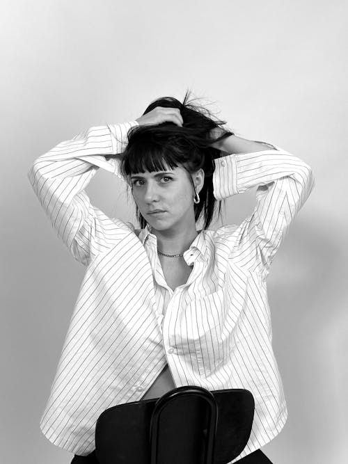 A woman sitting on a chair with her hair in her hands