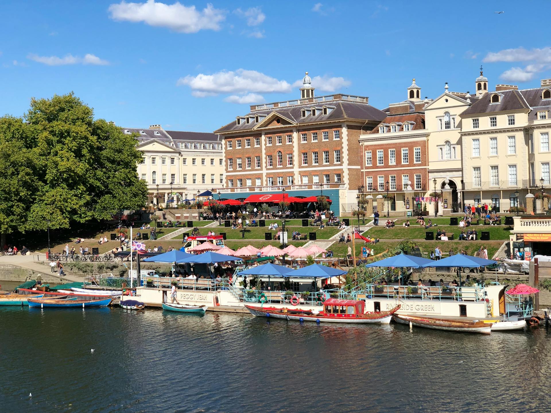 Vibrant scene of Richmond riverside with boats and historic buildings in summer.