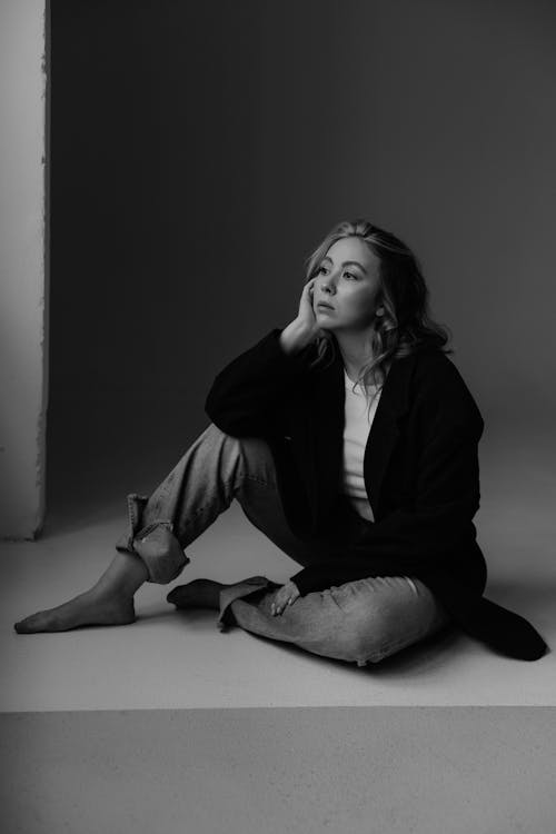 A woman sitting on the floor in black and white