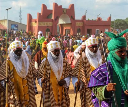 Vibrant traditional parade featuring men in ethnic attire, showcasing rich cultural heritage.