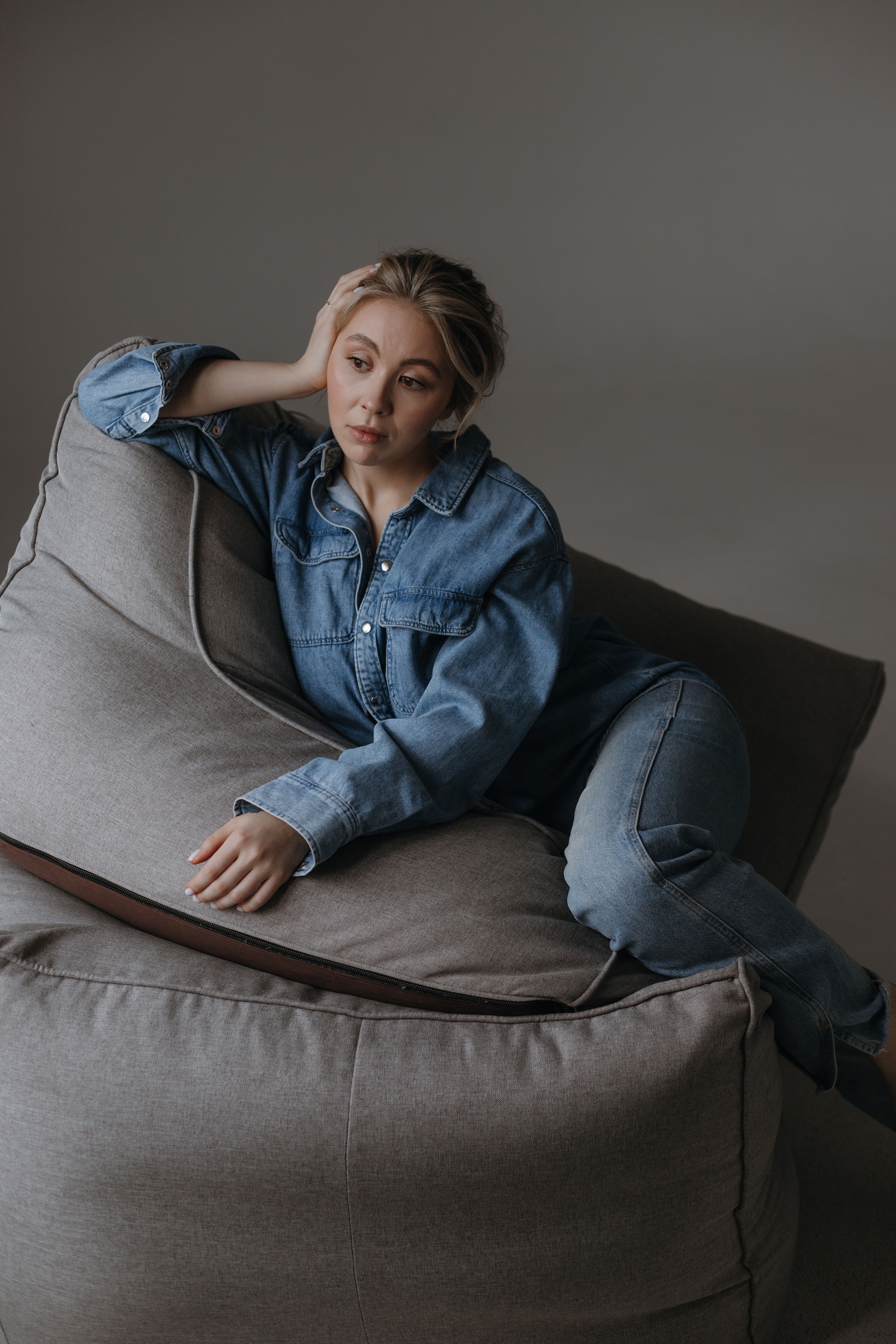 Woman wearing a lounge romper with a denim shirt