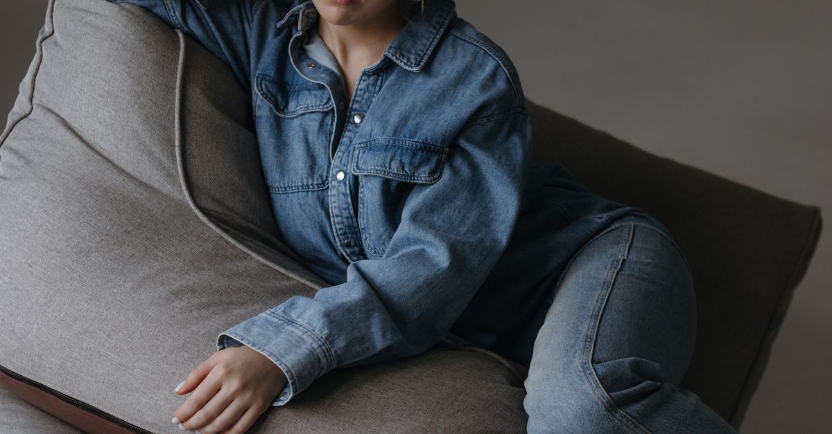 Woman wearing a lounge romper with a denim shirt