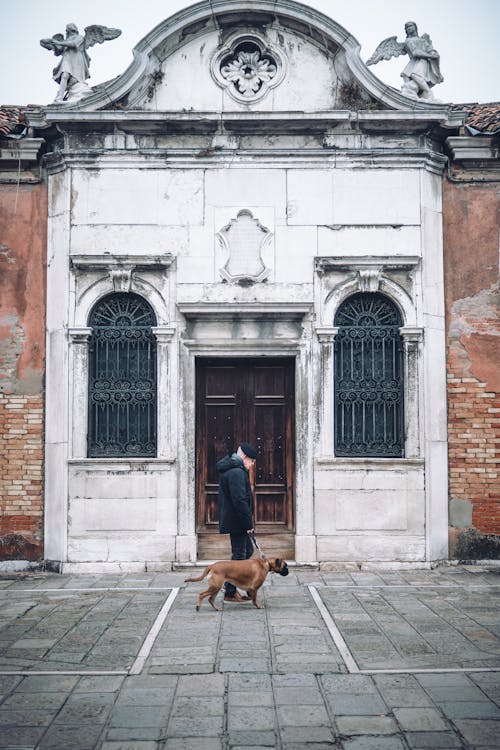 A man and a dog in front of a church