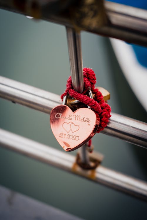 A heart shaped lock on a metal railing