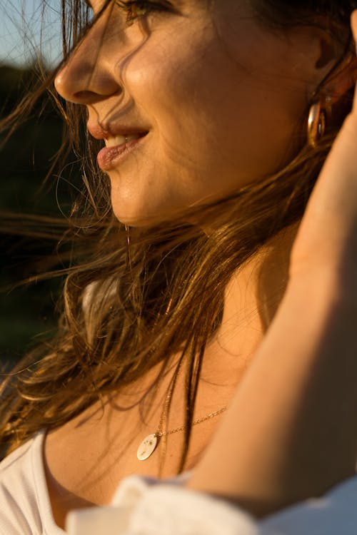 Sunlit Woman with Brown Hair and Necklace