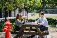 Man Sitting on Chair In Front of Woman