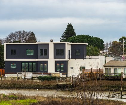 Contemporary two-story house near river with fresh architecture.