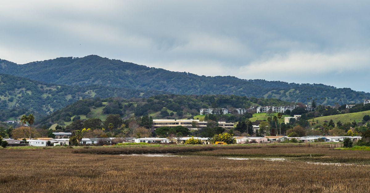 Picturesque rural landscape featuring homes nestled against rolling hills.