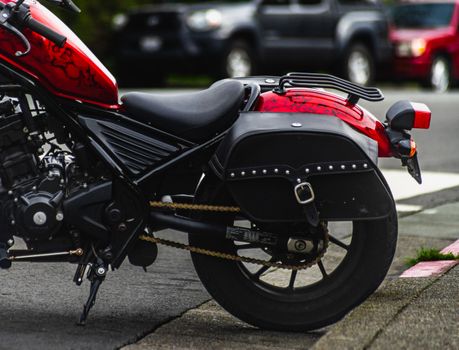 Detailed image of a motorcycle with a side bag parked in an urban setting.